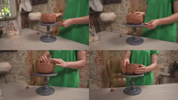 一个年轻的女性专业陶工在旋转支架上成型陶瓷锅的接近镜头。传统雕刻概念。陶土陶瓷产品