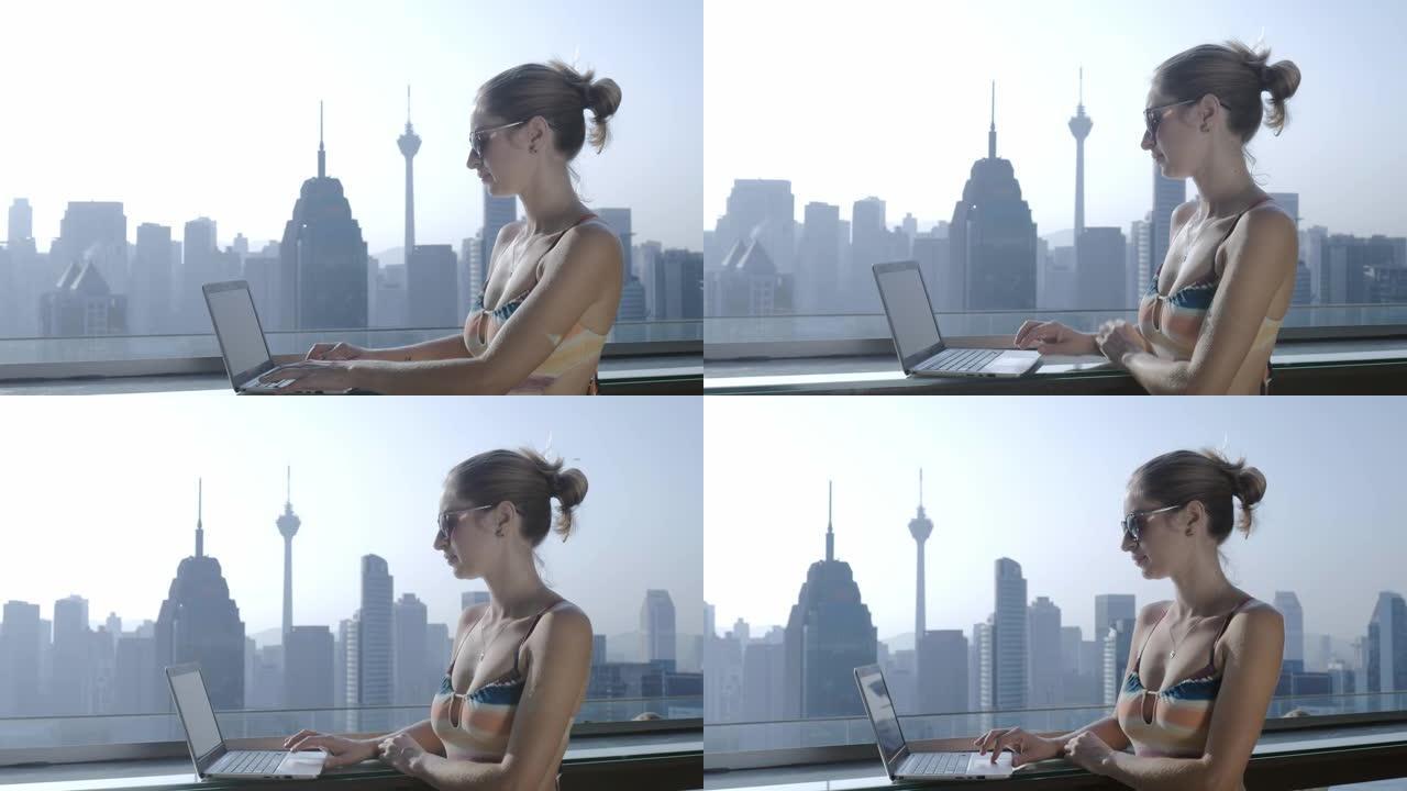 暑假期间在现代城市背景下使用笔记本电脑的自由职业者。