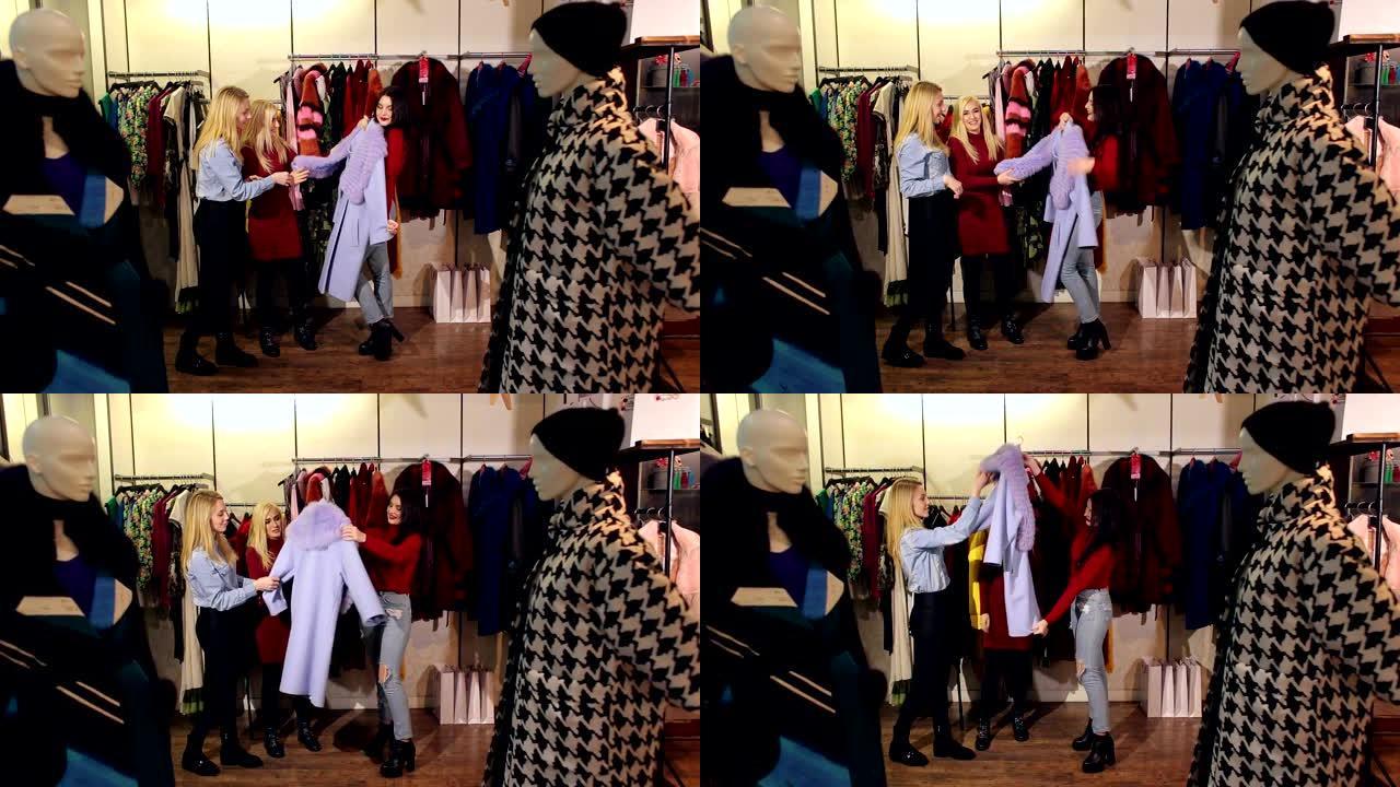 三个女孩走进一家服装店，她们看着衣服试穿。