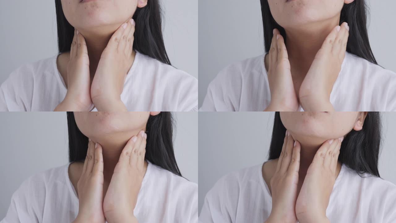 在家中白色背景下颈部疼痛的亚洲女性的特写镜头
