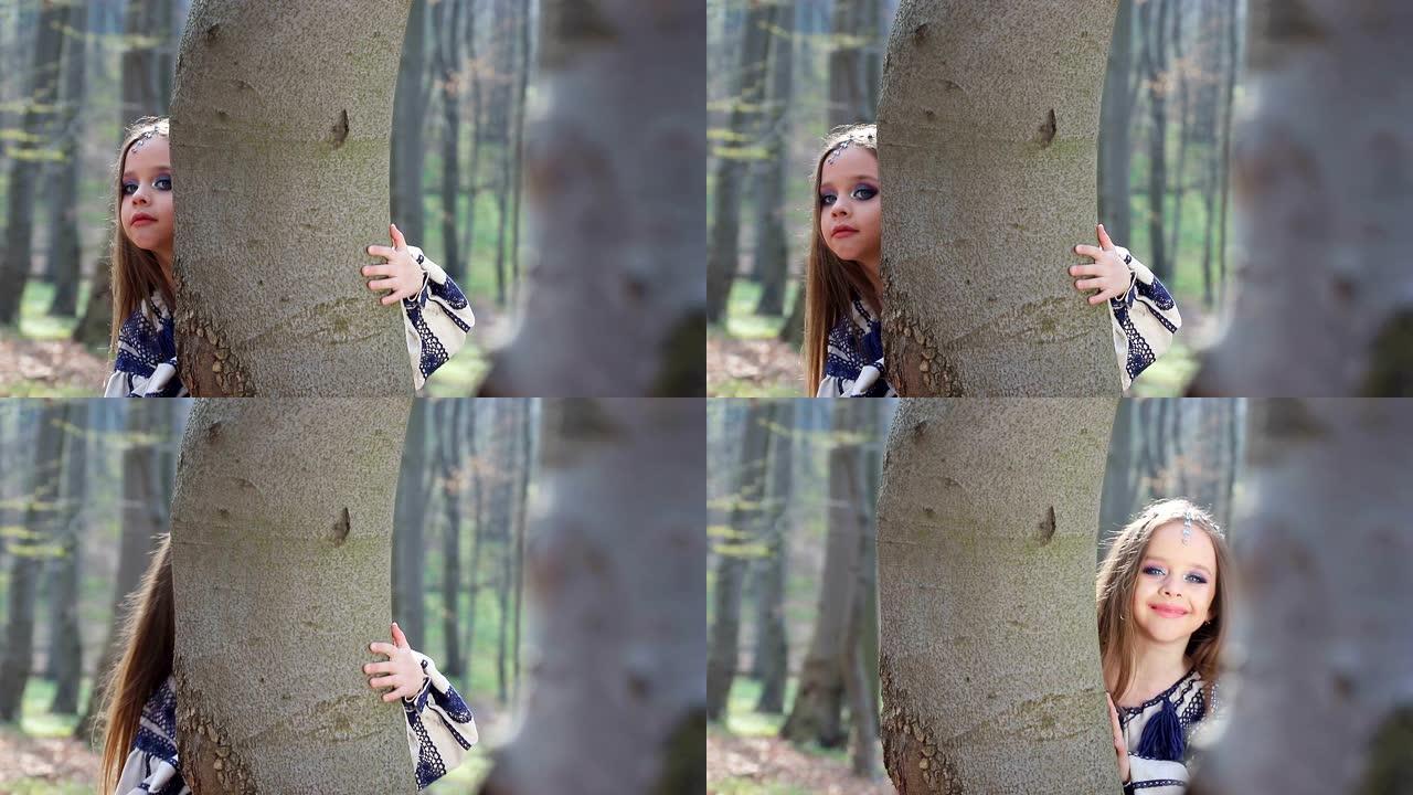 赤脚小女孩在森林或公园里奔跑，穿着蓝色图案的白色连衣裙躲在树后。