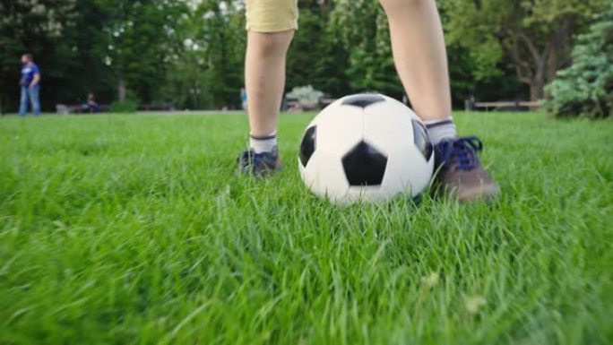 踢足球的男孩。带球的孩子穿过绿草