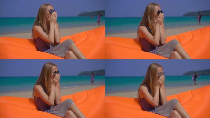 一名年轻女子坐在热带海滩上的充气沙发上咳嗽的超级镜头。旅行病概念