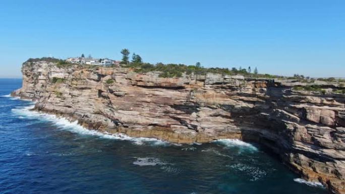 令人惊叹的4k全景空中无人机飞行的间隙，这是悉尼东部沃森湾郊区南头半岛上的海洋悬崖。背景中的悉尼中央