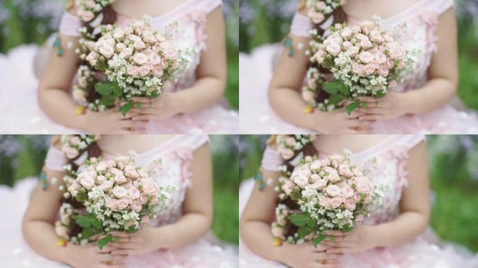 美丽的新娘在户外双手捧着一束花。
