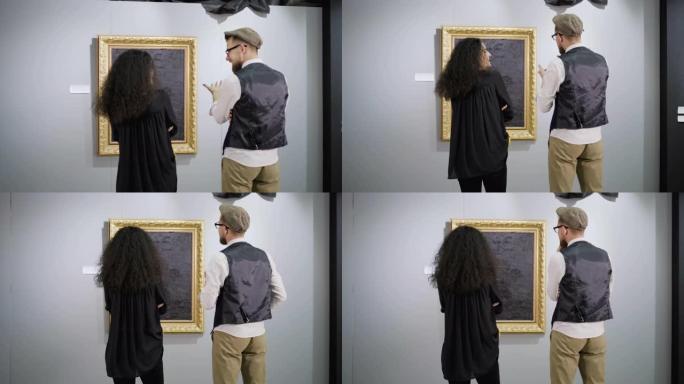 一对现代艺术展览的参观者在图片前聊天