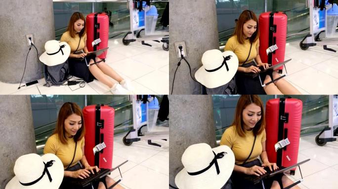 亚洲妇女在机场航站楼为笔记本电脑充电并在线工作
