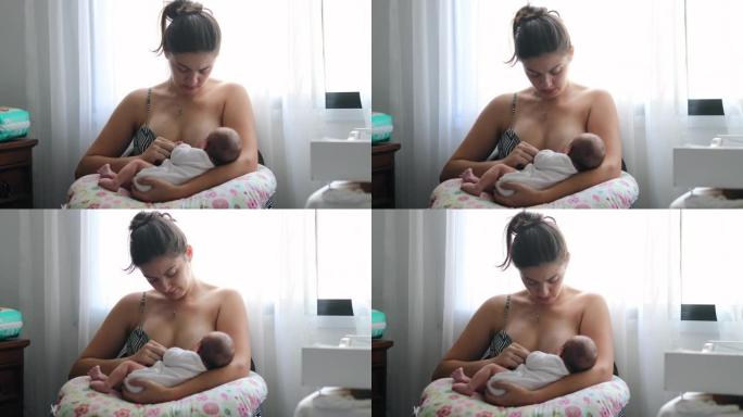 母亲在窗户旁边母乳喂养新生婴儿