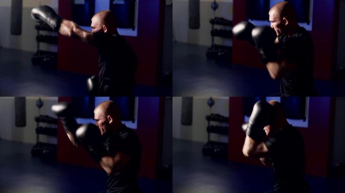 拳击手套里肌肉发达的拳击手在健身房里用阴影击打，慢动作。弱光场景