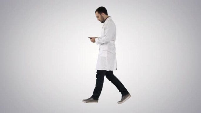 男医生走路和使用手机在梯度背景