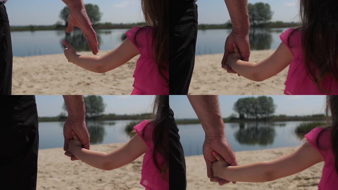 特写。孙女牵着祖父的手。他们前进。沿着湖边散步。4k慢速移动