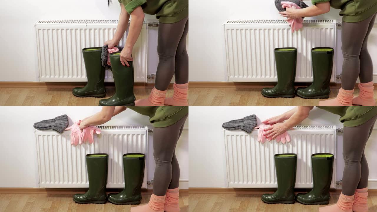 女人把湿靴子和手套放在暖气片附近晾干
