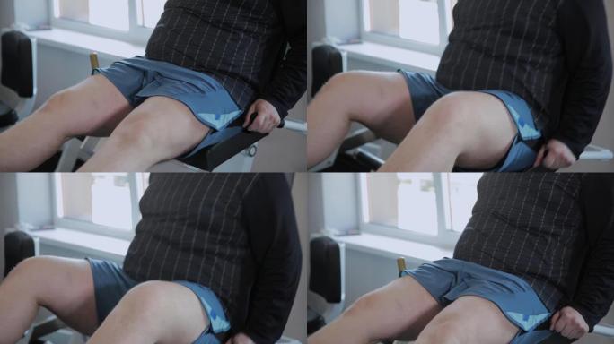 超重的成年男子将双腿压在模拟器上
