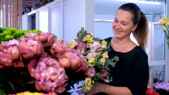 花店妇女制作大花束，并在花店与客户交谈。