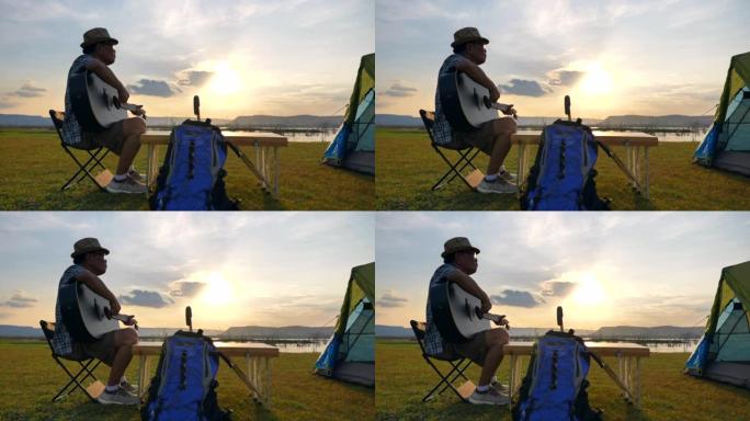 亚洲老人的场景慢动作正在弹吉他，在暑假期间欣赏湖边的景色。他很开心，在假期放松的时候也很开心。户外自