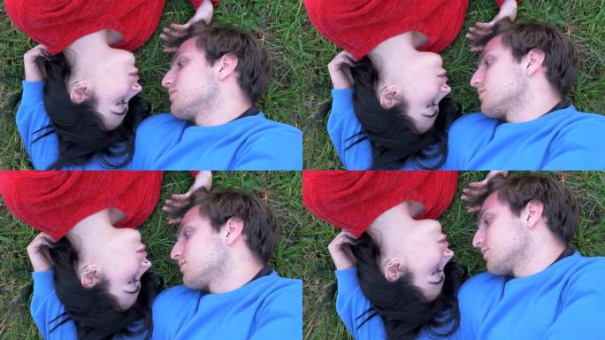 恋爱中的浪漫情侣看着彼此躺在草地上的眼睛