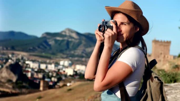 热情的年轻潮女使用专业相机拍摄山地自然摄影