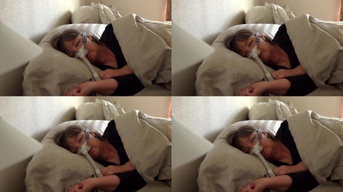患有睡眠呼吸暂停的中年妇女在床上睡觉，戴着CPAP (持续气道正压通气) 机器帮助她入睡