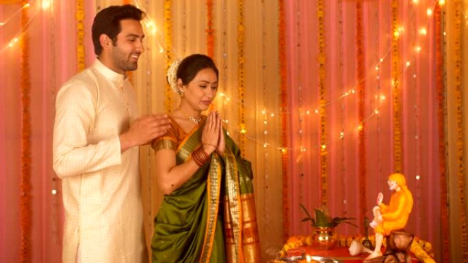 印度已婚夫妇在家里为法会穿着民族服装-向赛巴巴祈祷
