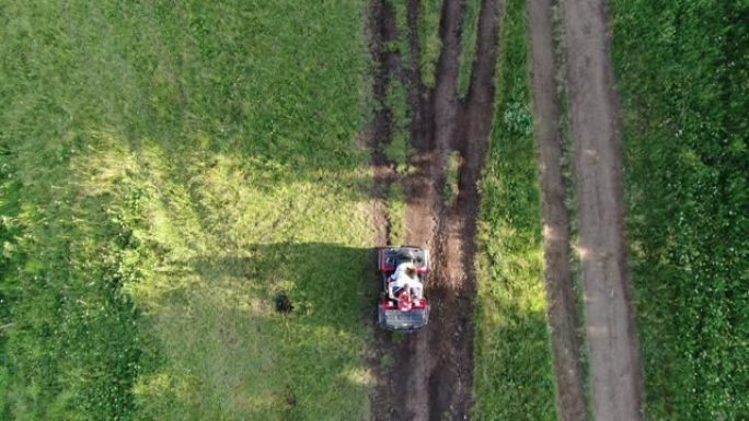 夫妇正在骑四轮摩托车。一对年轻游客的无人机空中射击正在日落时欣赏美丽的山脉景观