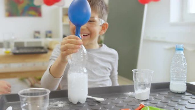 DS男孩在学校科学实验中让气球膨胀时大笑