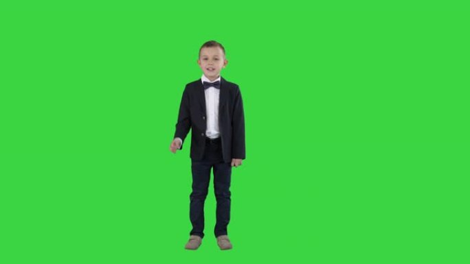 穿着西装的男孩走在一个框架里，开始在绿色屏幕上说话，色度键