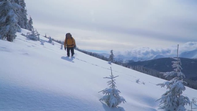 一位游客在山上的雪中漫步。