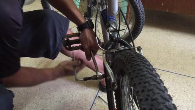 一名身份不明的自行车机械师修理自行车