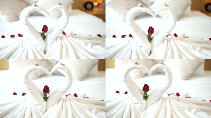卧室上有两条带花卉装饰的天鹅毛巾。