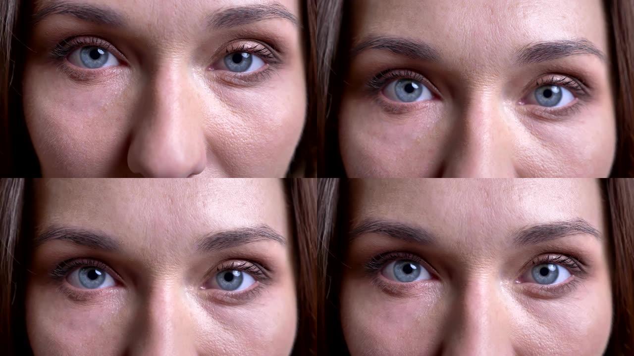 成年高加索女性脸的特写肖像，蓝眼睛被关闭，打开，直视相机