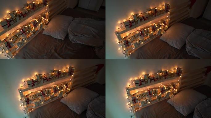 慢动作拍摄的降临日历挂在床上，上面用圣诞灯点亮。为圣诞节和新年概念做准备。降临日历概念