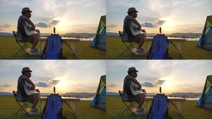 亚洲高级男性在唱歌时弹吉他的慢动作场景令人放松，并在暑假期间欣赏湖边的景色。他很开心，在假期、放松的