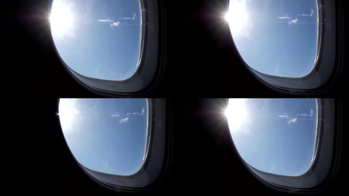 飞机飞行期间从窗户看到阳光明媚的蓝天。