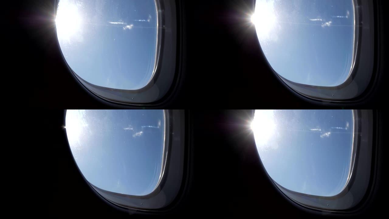 飞机飞行期间从窗户看到阳光明媚的蓝天。