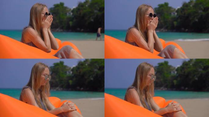 年轻女子坐在热带海滩上的充气沙发上咳嗽。旅行病概念