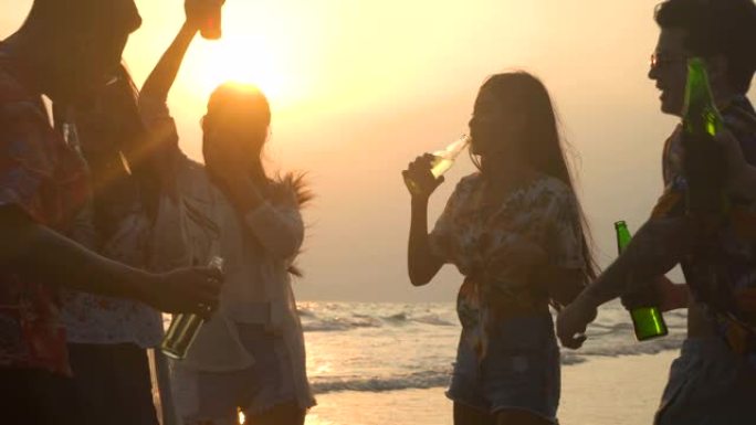 一群年轻人的剪影在周末举行沙滩派对并庆祝