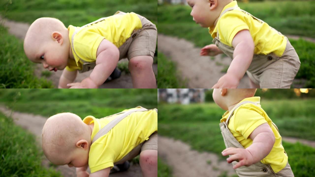 宝贝正在学习在草地上行走。又跌又涨。膝盖有划痕。婴儿的第一步