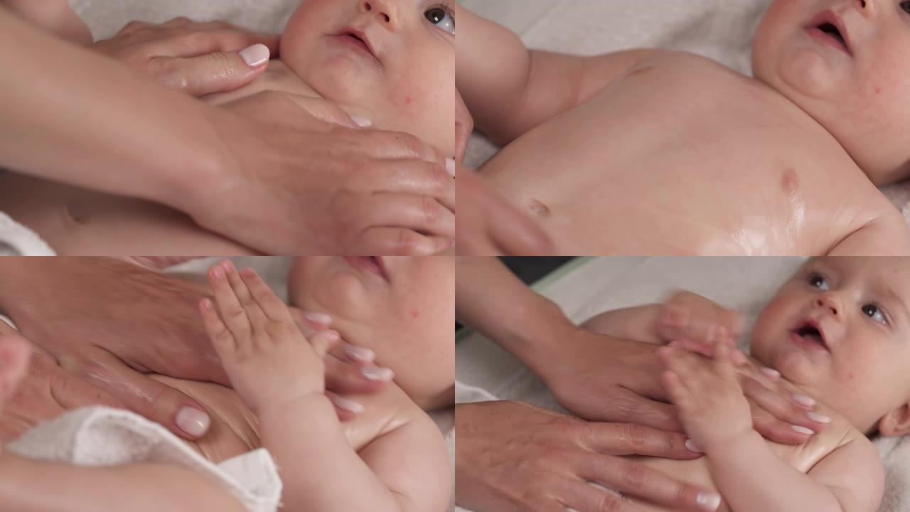 婴儿按摩。母亲在手掌上涂抹油，轻轻地给刚出生的婴儿做按摩。哺乳的孩子。儿童身体护理。特写