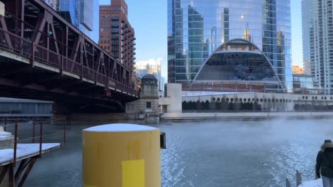 随着气温骤降和通勤者聚集在雪地上，蒸汽从芝加哥河的水中升起。