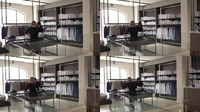 店员的演示视频将新的男性服装放在货架上。时装店日常工作。收到新的衣服收藏