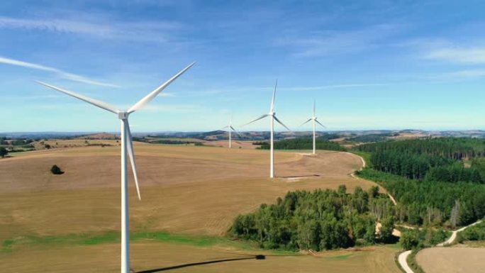 风力涡轮机在蓝天下的田野里转动。他们正在产生清洁的可租用能源-无人机鸟瞰图-环境和生态概念