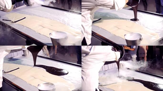 专业厨师用vapoup将白色和黑色的奶油液体倒在表面上。