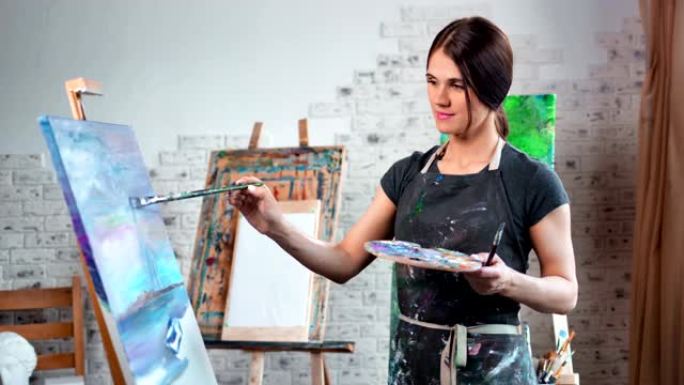 才华横溢的年轻女画家喜欢用画笔中拍在画布上画画