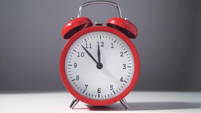 老式红色闹钟，午夜或中午前倒计时十五分钟。除夕抽象概念。