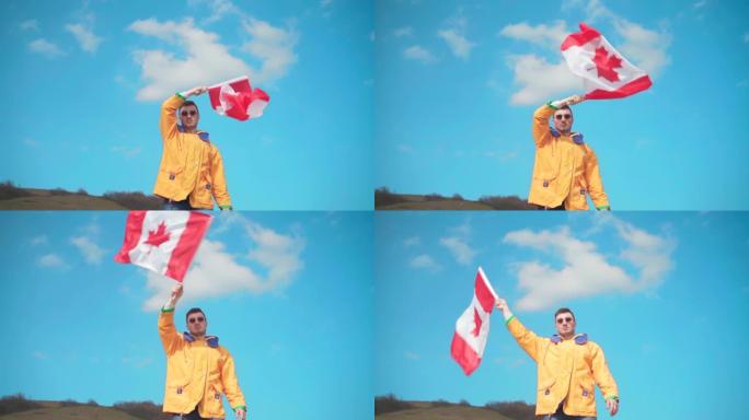一个穿着黄色夹克，蓝色牛仔裤和眼镜的男人站在山上，从一侧到另一侧挥舞着加拿大国旗。