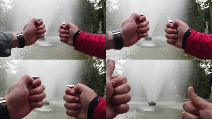男性和女性的手向喷泉扔硬币以求好运。