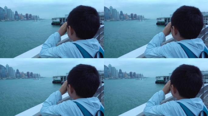 亚洲男孩用双筒望远镜看香港建筑物