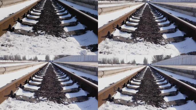 空的铁路道路被雪覆盖，被太阳照亮。