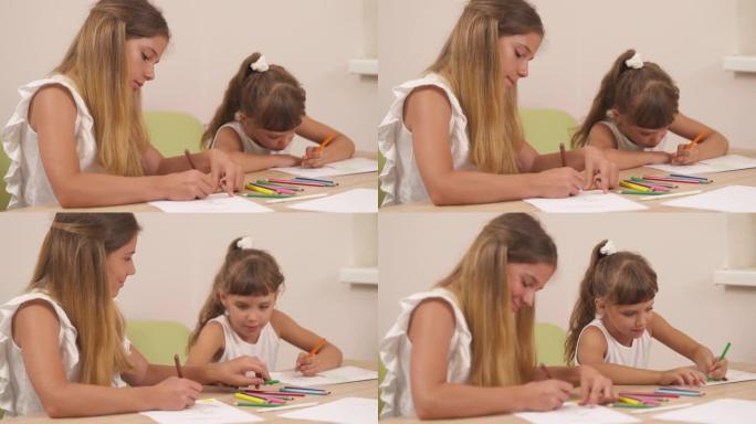 两个可爱的女孩在心理会议上仔细画画的特写。家庭心理学