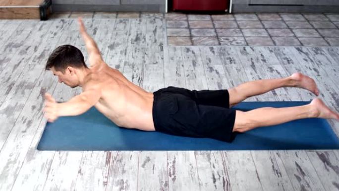 体格健壮的男性躺在肚子上练习瑜伽运动享受健康的生活方式高角度